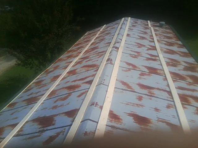 Rusted metal roof panels with new wood purlins before replacement — Storm Damage Roof Repair in Thomasboro by Roofing Brothers