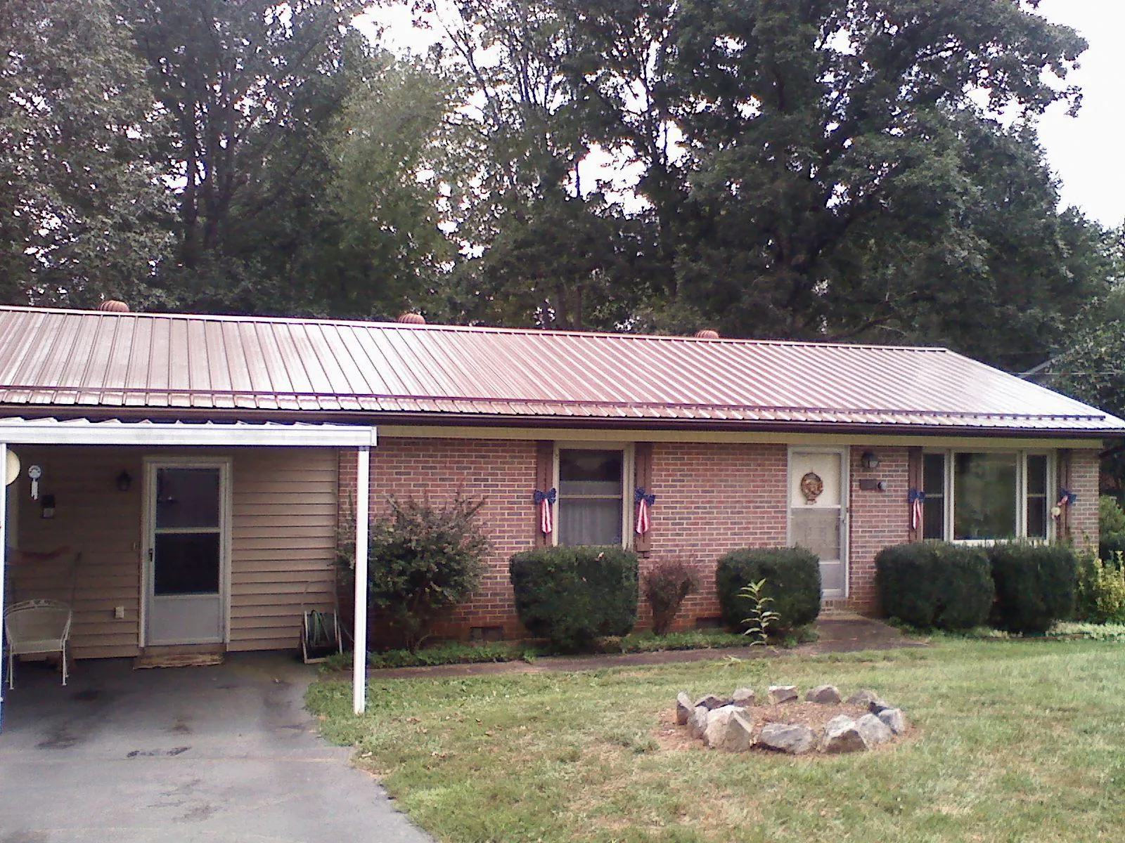 Bronze metal roof and carport on a brick ranch home — Roof Repair work by our crew in Thomasboro